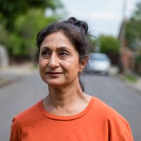 Close up off a pakistani woman outdoors looking away from the camera while on a run in a residential area in the North East of England.